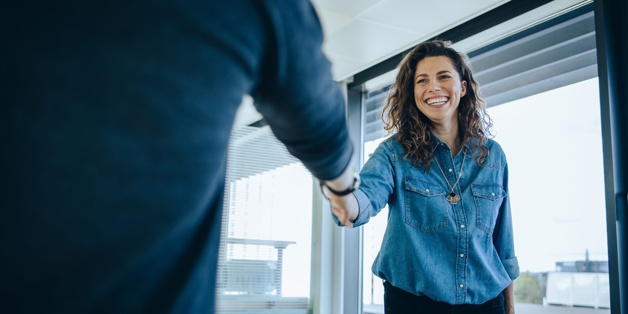Businesswoman shaking hands with a job applicant Title: What Makes for Successful Consumer Brand Talent Acquisition in 2023