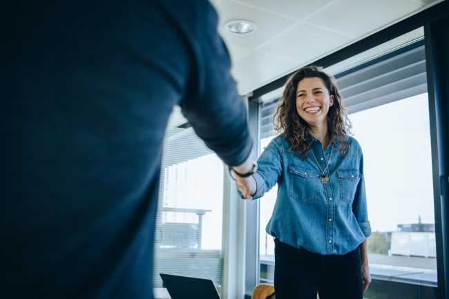 Businesswoman shaking hands with a job applicant Title: What Makes for Successful Consumer Brand Talent Acquisition in 2023