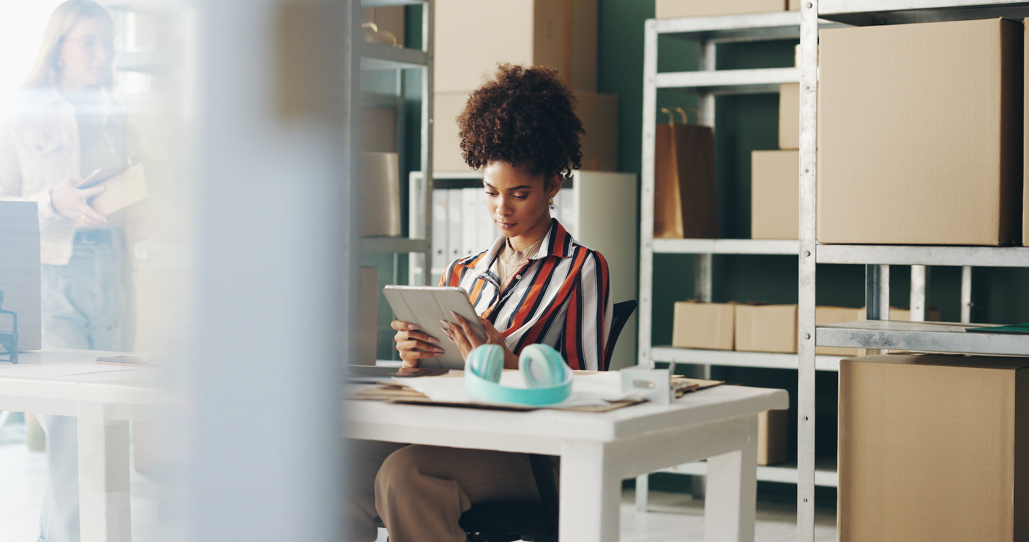 Woman, tablet and distribution for shipping in office, planning and ecommerce order in storage. Female person, online and supply chain for delivery logistics, stock and digital checklist for boxes Navigating the Evolving Landscape: Hiring for CPG eCommerce Success
