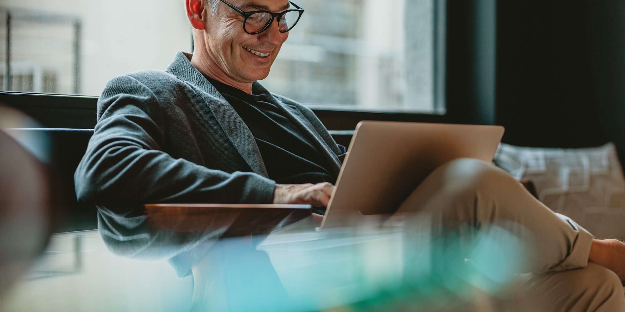 Business professional working on laptop in office lobby How a CPG Agency Like Hunter & Michaels Transforms Executive Recruitment in the Consumer Packaged Goods Industry