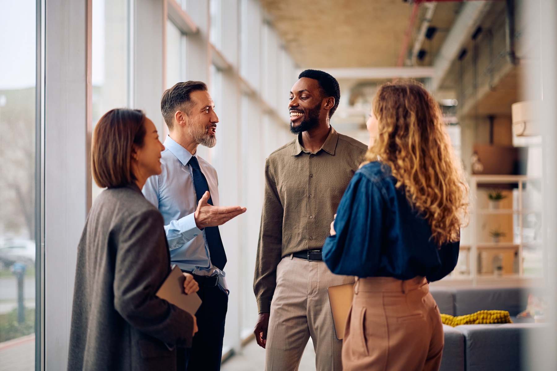 Happy multiracial business team talking in the office. The CPG COO Skill Set Has Changed. Has Your Recruiting Process Caught Up?